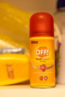 Bir raftaki çoklu böcek spreyi şişesinin dikey yakın çekimi.