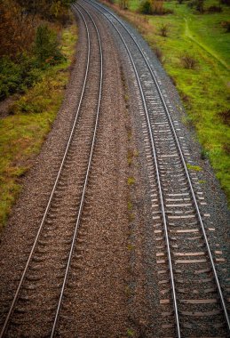Farklı renklerde taşlarla kaplı iki tren yolunun dikey yüksek açısı.