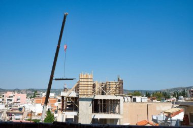 Kendi kendine hareket eden vinç, inşa edilmiş bir binaya demir maddeler boşaltıyor.