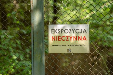 Metal parmaklıklar üzerindeki bir yazı tahtası Lehçe serginin yeni hayvanat bahçesinde arızalı olduğunu söylüyor..