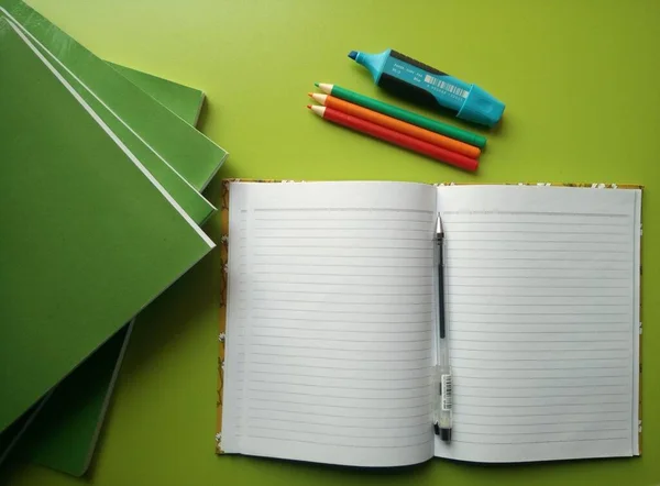 Een Open Boek Een Groene Tafel Met Grote Boeken Briefpapier — Stockfoto