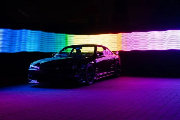 カラフルなネオンライトを反射してクールなスポーツカーのシルエット — ストック写真