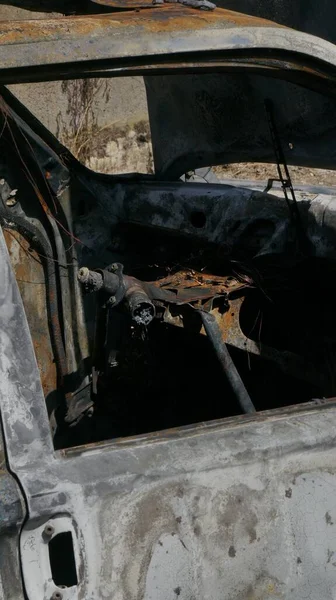 道端に放置された燃えた車の垂直ショット — ストック写真