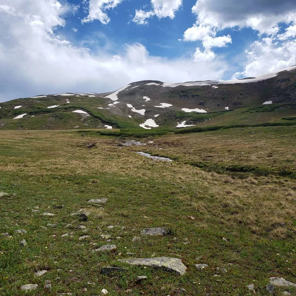 Green Field Snow Covered Mountain Top Cloudy Sky — Stock Photo, Image