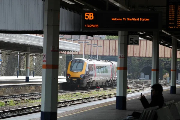 英国南约克郡谢菲尔德 一列带月台和乘客的越野车从火车站开出的照片 — 图库照片