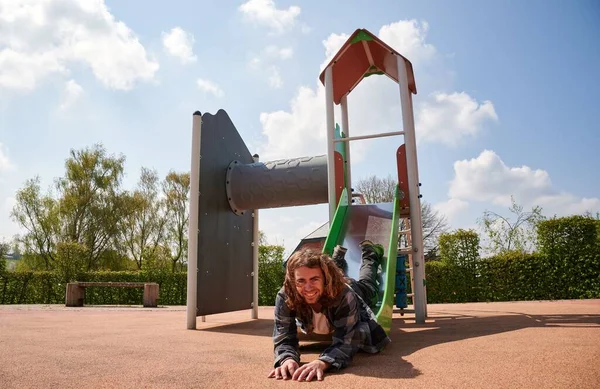 Çocukların Üzerinde Neşeli Beyaz Bir Adam Oyun Parkında Kayıyor — Stok fotoğraf