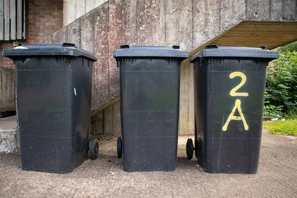 Closeup Three Black Garbage Cans Front Stair Wall Outdoors — Stock Photo, Image