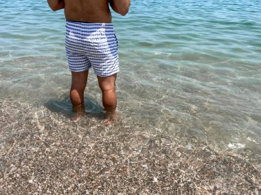 Bilinmeyen adam sahilde duruyor.