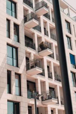 Balkonları olan modern bir konut binasının dizaynının dikey görüntüsü.
