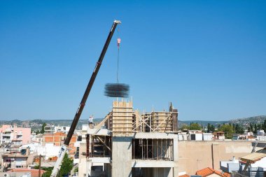 Kendi kendine hareket eden vinç, inşa edilmiş bir binaya demir maddeler boşaltıyor.