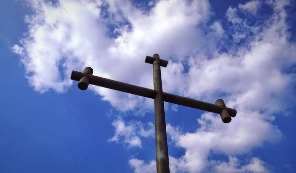 Nízký Úhel Výstřelu Kovového Kříže Pod Modrou Oblohou Mraky — Stock fotografie