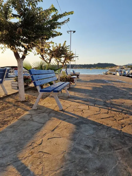 Piękne Ujęcie Słonecznej Plaży Niebieskimi Ławkami — Zdjęcie stockowe