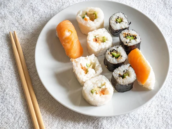 Primer Plano Sushi Plato Junto Palillos Una Superficie Blanca —  Fotos de Stock