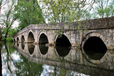 Saraybosna 'daki Rimski Most' un güzel bir manzarası. Nehre yansıyan ağaçlarla birlikte.