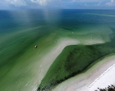 Mavi ve yeşil sakin okyanus suyuyla kıyıya vuran küçük dalgalar