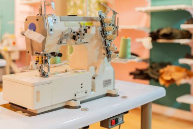 Dikiş atölyesindeki bir masanın tepesindeki dikiş makinesine odaklan