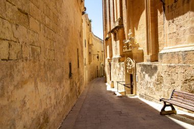 Malta 'daki taş binalar arasında dar bir ara sokak.