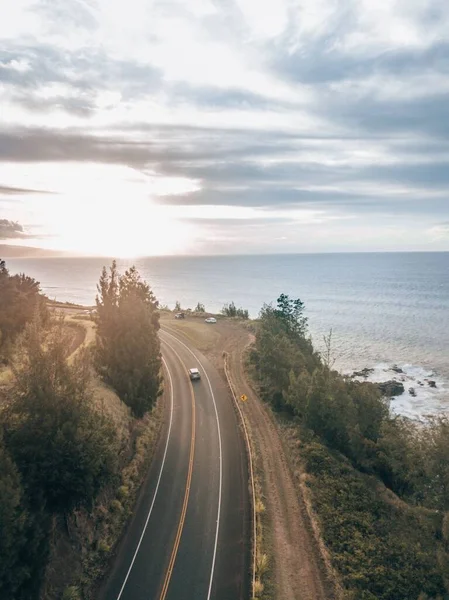 ハワイの日没時に海に向かって高速道路を走行する車の空中ビュー — ストック写真