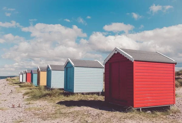 Die Reihen Von Bunten Strandschuppen Auf Kieselstrand Auf Blauem Bewölkten — Stockfoto