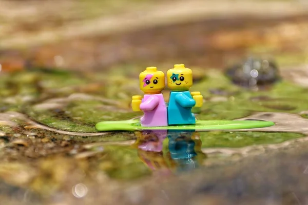 Lächelnde Baby Spielzeugfigur Auf Einem Grünen Surfbrett Das Wasser Schwimmt — Stockfoto