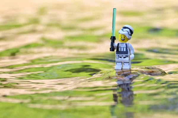 Katona Műanyag Mosolygós Játékfigura Sisakot Viselő Tartozékkal Víz Mellett Áll — Stock Fotó