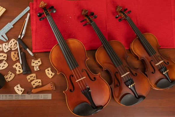 Vista Superior Três Violinos Uma Oficina Com Diferentes Ferramentas Para — Fotografia de Stock