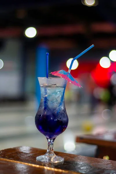 우산으로 장식된 유리잔에 파란색 칵테일을 수직으로 클로즈업 — 스톡 사진