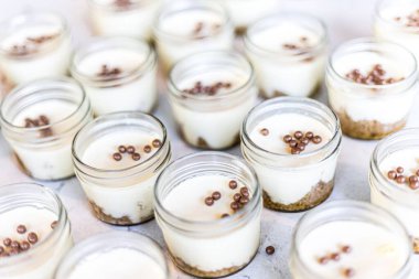 Yan yana dizilmiş yuvarlak cam kaselerdeki tatlıların yüksek açılı çekimi.