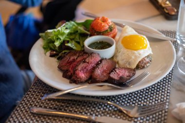 Bir tabak et, yumurta ve sebze dilimlerinin seçici odak noktası.