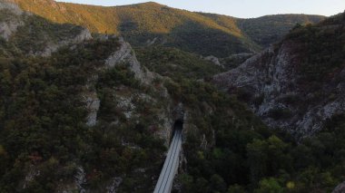 Tünele giren bir demiryolu ile doğal manzaranın güzelliği.