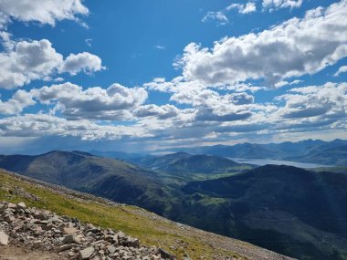 Dağın yamacından manzaraya bulutlu gökyüzünün altında