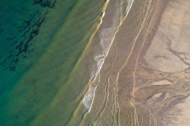 Turkuaz su plajında hafif dalgalar, hava manzarası.