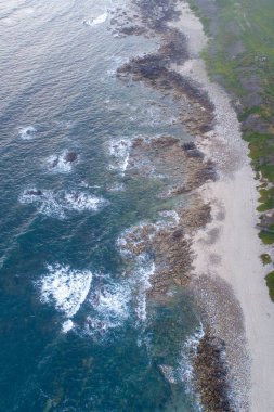 Kayalık kıyılarda okyanus dalgaları kırılıyor.