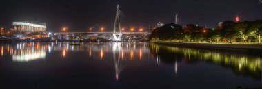 Şehir ışıkları gece boyunca nehirde yansıyor.