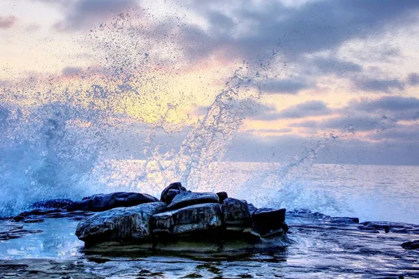 Ein Malerischer Blick Auf Ozeanwellen Die Bei Sonnenuntergang Gegen Felsen — Stockfoto