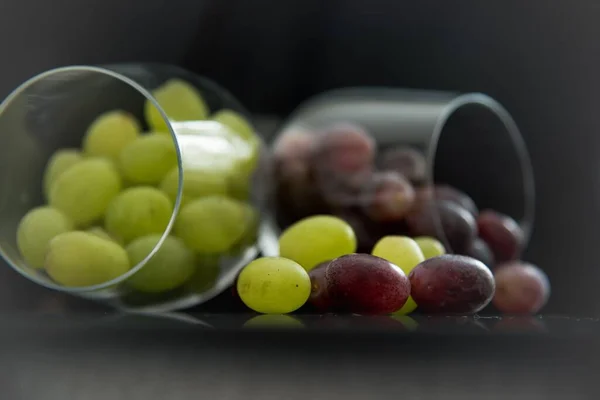 Ujęcie Bliska Winogron Spadających Przezroczystych Szklanek Stół — Zdjęcie stockowe