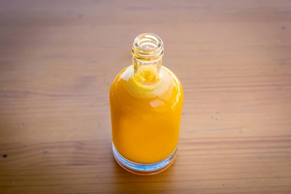 Eine Hochauflösende Aufnahme Einer Flasche Saft Auf Einem Holztisch — Stockfoto