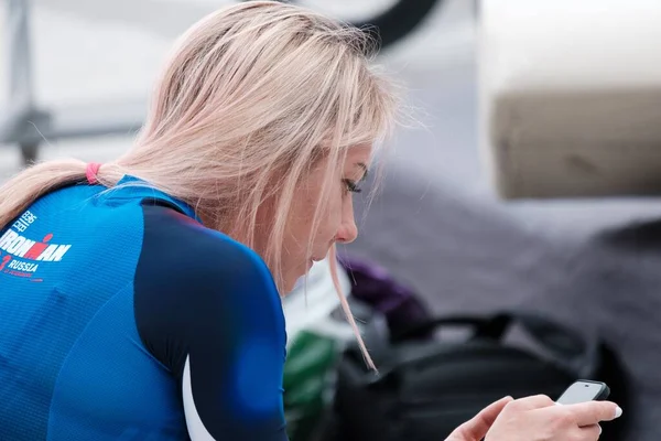 Blondýnka Plavecké Uniformě Dívá Svůj Telefon — Stock fotografie