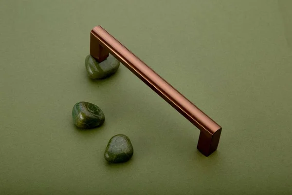 光沢のある銅製のプルハンドルと緑の表面に緑の天然石 — ストック写真