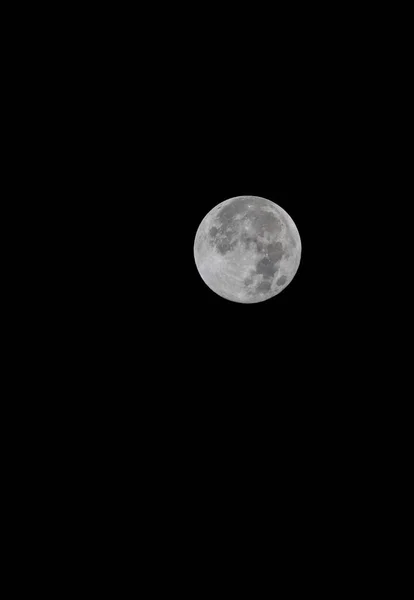 在黑暗的天空中拍摄到满月的垂直特写 — 图库照片