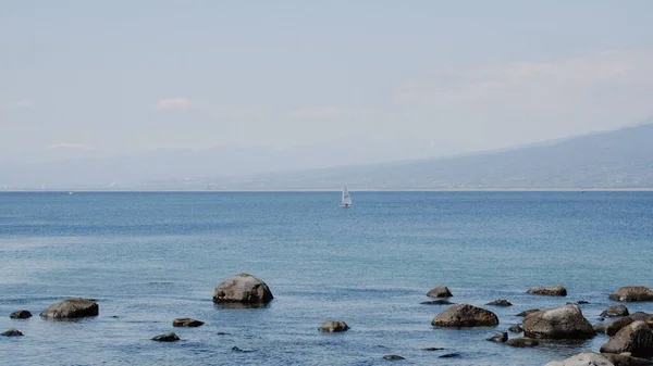 Piękny Widok Spokojne Morze Kilkoma Kamieniami Małą Łódką Środku — Zdjęcie stockowe