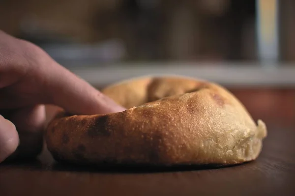 自制的酸面饼面包用一根手指压住 — 图库照片