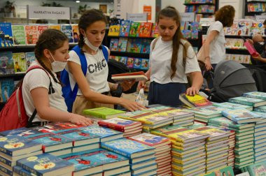 İtalya, Torino 'daki uluslararası kitap fuarında kitap arayan üç genç.