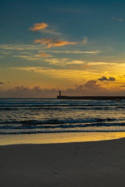 Sahildeki bu çarpıcı gün batımını takdir ediyorum.