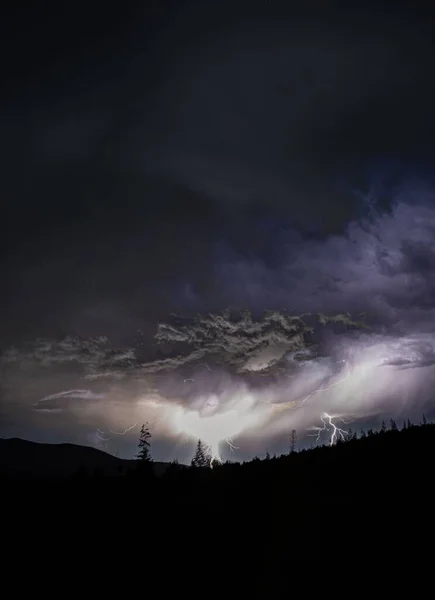 Драматическое Темное Облачное Небо Молнией Над Силуэтами Деревьев — стоковое фото