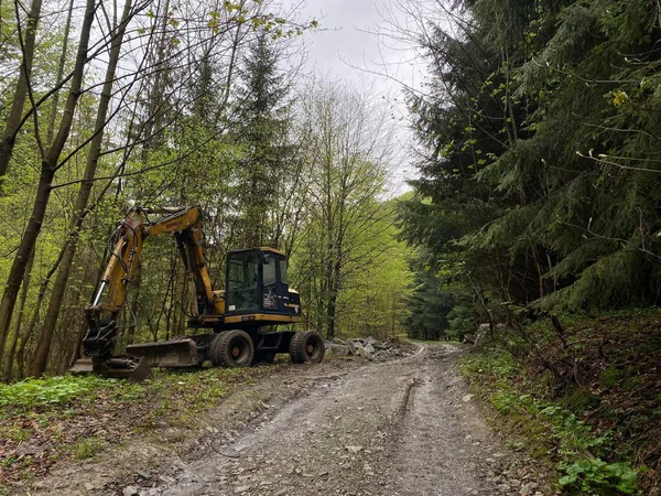 新しい開発のための森林をクリアするパスに沿って掘削機 — ストック写真