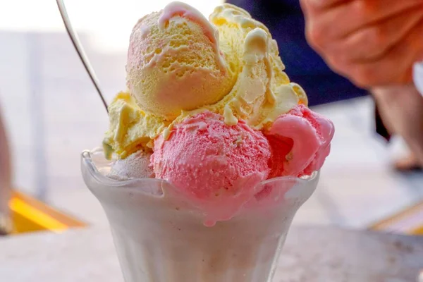 A closeup of colorful ice cream in a cup on a table
