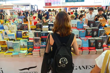 İtalya, Torino 'daki Uluslararası Kitap Fuarı' nda kitap standının yanında duran bir kadının arka görüntüsü.
