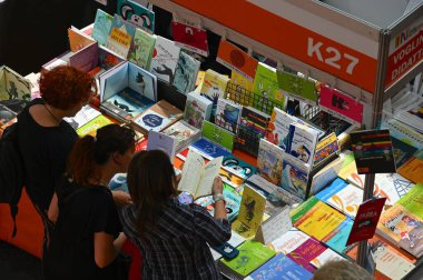 İtalya, Torino 'daki Uluslararası Kitap Fuarı' nda bir kitap standının yanında duran bir grup genç kadın.
