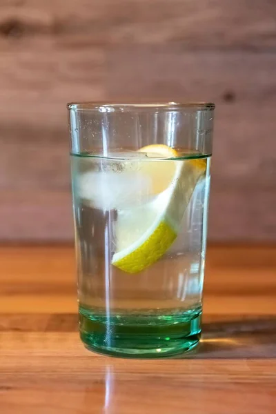 Cam Bir Bardaktaki Limon Suyunun Dikey Görüntüsü Ahşap Bir Masada — Stok fotoğraf